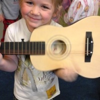 Difference Between Preschool and Daycare 1 daycare in Colorado springs, image of child with a guitar.