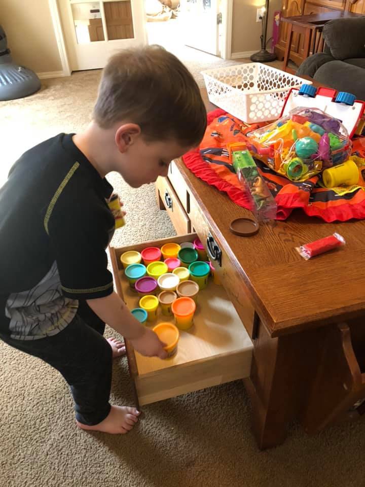 child organizing toys in drawer