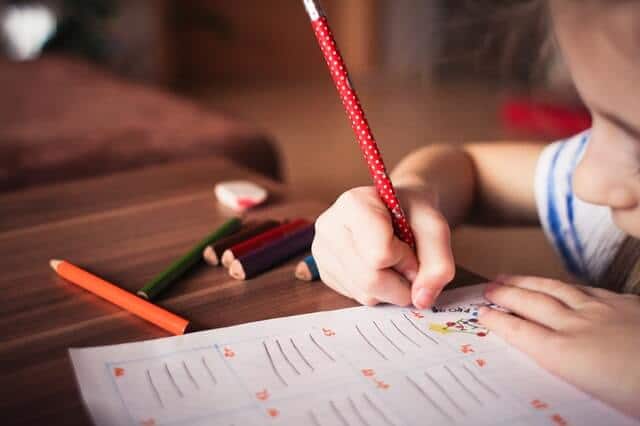 child in a classroom writing